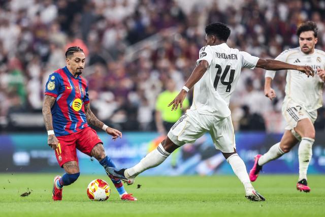 Barcelona's Brazilian forward #11 Raphinha (L) and Real Madrid's French midfielder #14 Aurelien Tchouameni fight for the ball during the Spanish Super Cup final football match between FC Barcelona and Real Madrid at the King Abdullah Stadium in Jeddah on January 11, 2026. (Photo by Haitham AL-SHUKAIRI / AFP)