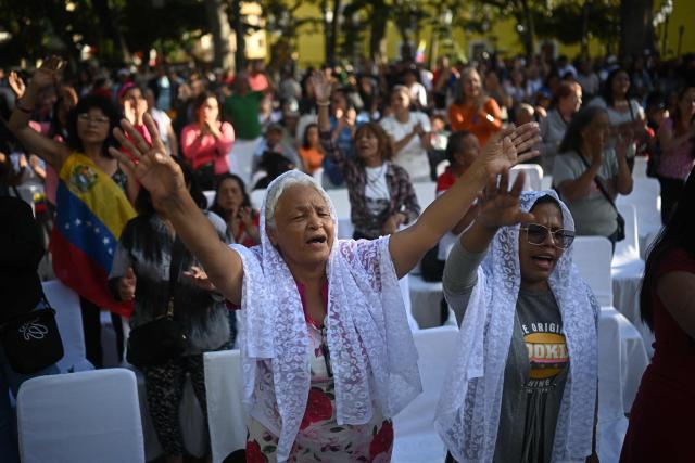 An Evangelical woman prays during an event in support of deposed Venezuelan president Nicolas Maduro and his wife Cilia Flores, at Plaza Bolivar in Caracas on January 11, 2026.  (Photo by Federico PARRA / AFP)