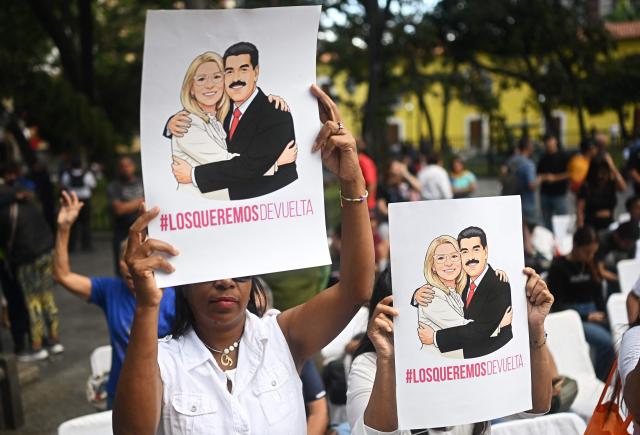 Evangelical faithfuls hold images of deposed Venezuelan president Nicolas Maduro and his wife Cilia Flores during a rally in their support at Plaza Bolivar in Caracas on January 11, 2026.  (Photo by Federico PARRA / AFP)