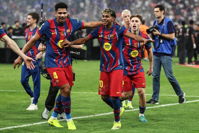 Barcelona's Uruguayan defender #04 Ronald Federico Araujo da Silva and Barcelona's Spanish forward #10 Lamine Yamal celebrate after winning the Spanish Super Cup final football match between FC Barcelona and Real Madrid at the King Abdullah Stadium in Jeddah on January 11, 2026. (Photo by Fadel SENNA / AFP)