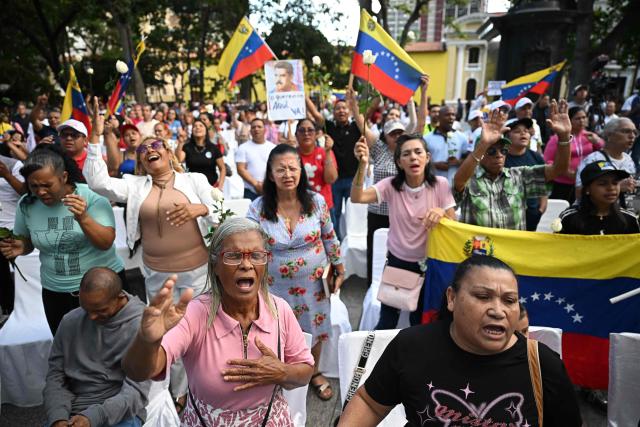 A group of Evangelicals pray during an event in support of deposed Venezuelan president Nicolas Maduro and his wife Cilia Flores, at Plaza Bolivar in Caracas on January 11, 2026.  (Photo by Federico PARRA / AFP)