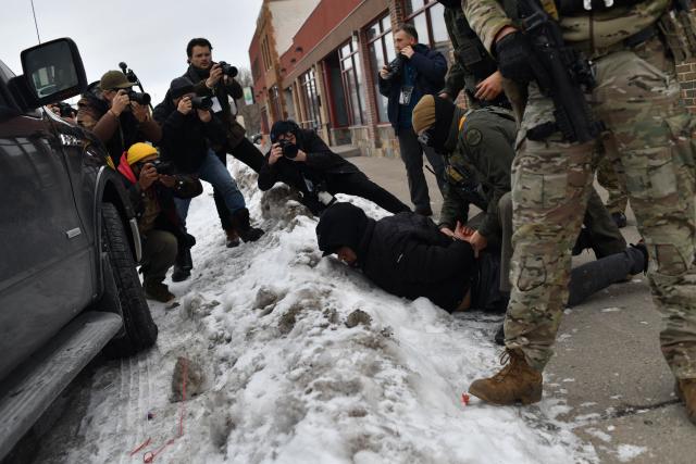 TOPSHOT - US Customs and Border Protection agents arrest a man after not providing documents proving he’s a citizen of the United States while patrolling a neighborhood during immigration enforcement activity in Minneapolis in Minneapolis, Minnesota, on January 11, 2026. A US Immigration and Customs Enforcement (ICE) agent shot and killed 37-year-old Renee Nicole Good on the streets of Minneapolis on January 7, leading to huge protests and outrage from local leaders who rejected White House claims she was a domestic terrorist. (Photo by Octavio JONES / AFP)