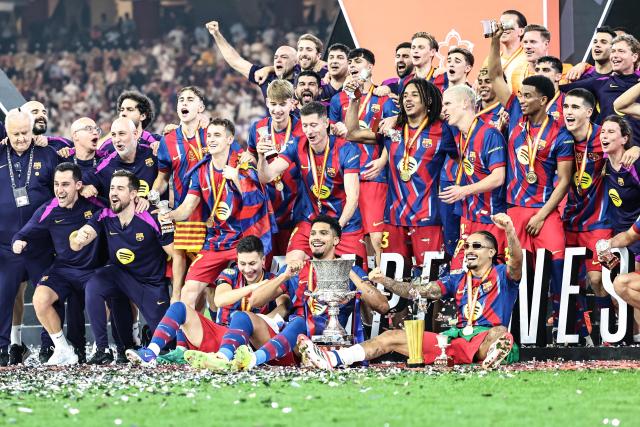 Barcelona's players celebrate with the trophy after winning the Spanish Super Cup final football match between FC Barcelona and Real Madrid at the King Abdullah Stadium in Jeddah on January 11, 2026. (Photo by Haitham AL-SHUKAIRI / AFP)