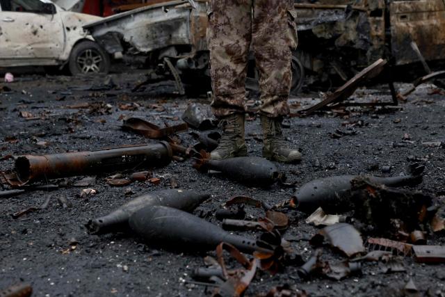 A Syrian security officer stands next to munition strewn on the ground following a ceasefire which ended several days of fighting between Syrian security forces and Kurdish fighters in the Kurdish-majority Sheikh Maqsud neighbourhood, of the northern city of Aleppo on January 11, 2026. Syria's Kurdish fighters said on January 11, 2026, that they agreed under a ceasefire to withdraw after days of fighting government forces in the city. The latest clashes erupted after negotiations to integrate the Kurds into the country's new government stalled. (Photo by Bakr ALkasem / AFP)