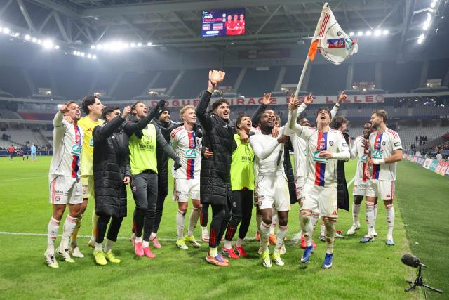 TOPSHOT - Lyon's team players celebrate their victory after the French Cup round of 32 football match between Lille OSC and Olympique Lyonnais at the Stade Pierre-Mauroy in Villeneuve-d'Ascq, northern France on January 11, 2026. (Photo by Francois LO PRESTI / AFP)
