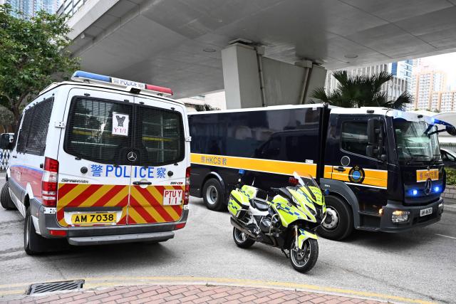 A vehicle (R) believed to be transporting convicted pro-democracy media tycoon Jimmy Lai arrives at the West Kowloon Magistrates' court in Hong Kong on January 12, 2026. A Hong Kong court will hear sentencing arguments on January 12 for pro-democracy media tycoon Jimmy Lai, who was convicted of national security crimes that could land him in prison for life. (Photo by Peter PARKS / AFP)