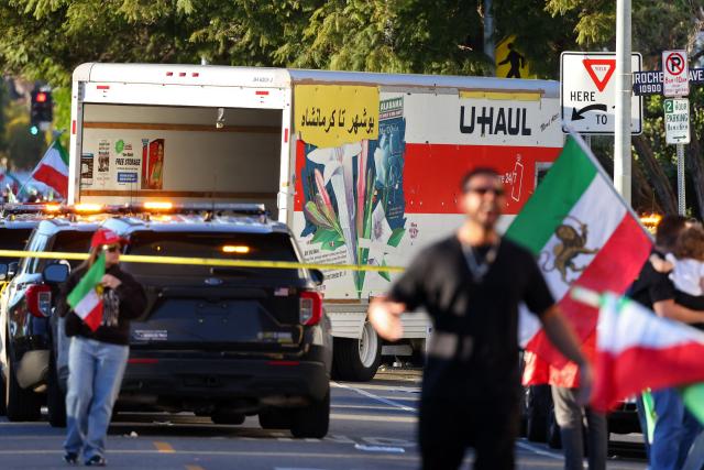 People walk near a U-Haul truck that reportedly was driven into a crowd during an anti-Iranian regime rally on January 11, 2026 in Los Angeles, California. The Norway-based NGO Iran Human Rights (IHR) said it had confirmed the killing of at least 192 protesters but warned the actual death toll could already amount to several hundreds, or even more. The IHR has an extensive network of sources in the country. The protests, initially sparked by anger over the rising cost of living, have evolved into a movement against the theocratic system in place in Iran since the 1979 revolution. They have already lasted two weeks. (Photo by Jonathan Alcorn / AFP)