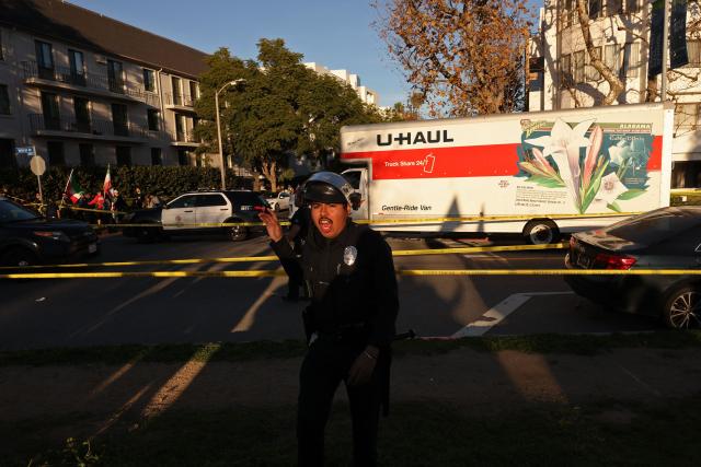 People walk near a U-Haul truck that reportedly was driven into a crowd during an anti-Iranian regime rally on January 11, 2026 in Los Angeles, California. The Norway-based NGO Iran Human Rights (IHR) said it had confirmed the killing of at least 192 protesters but warned the actual death toll could already amount to several hundreds, or even more. The IHR has an extensive network of sources in the country. The protests, initially sparked by anger over the rising cost of living, have evolved into a movement against the theocratic system in place in Iran since the 1979 revolution. They have already lasted two weeks. (Photo by Jonathan Alcorn / AFP)