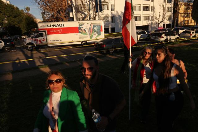 People walk near a U-Haul truck that reportedly was driven into a crowd during an anti-Iranian regime rally on January 11, 2026 in Los Angeles, California. The Norway-based NGO Iran Human Rights (IHR) said it had confirmed the killing of at least 192 protesters but warned the actual death toll could already amount to several hundreds, or even more. The IHR has an extensive network of sources in the country. The protests, initially sparked by anger over the rising cost of living, have evolved into a movement against the theocratic system in place in Iran since the 1979 revolution. They have already lasted two weeks. (Photo by Jonathan Alcorn / AFP)