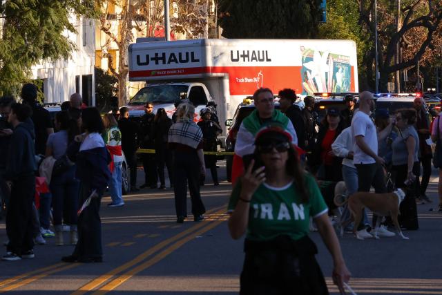 People walk near a U-Haul truck that reportedly was driven into a crowd during an anti-Iranian regime rally on January 11, 2026 in Los Angeles, California. The Norway-based NGO Iran Human Rights (IHR) said it had confirmed the killing of at least 192 protesters but warned the actual death toll could already amount to several hundreds, or even more. The IHR has an extensive network of sources in the country. The protests, initially sparked by anger over the rising cost of living, have evolved into a movement against the theocratic system in place in Iran since the 1979 revolution. They have already lasted two weeks. (Photo by Jonathan Alcorn / AFP)