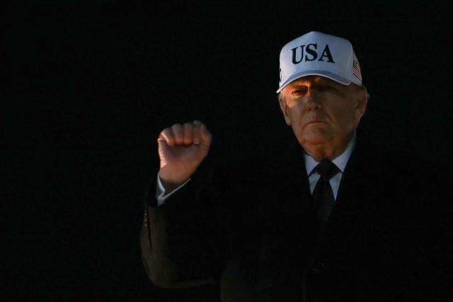 US President Donald Trump pumps his fist as he walks to board Marine One at Joint Base Andrews in Maryland on January 11, 2026. (Photo by ANDREW CABALLERO-REYNOLDS / AFP)