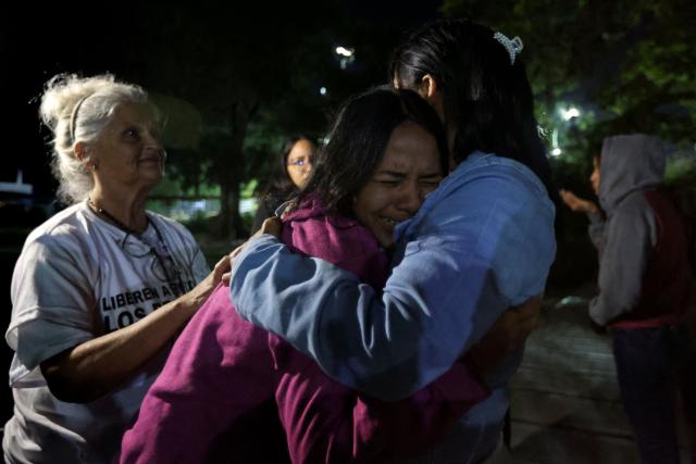 Lorealbert Gutierrez, (C) 19, is comforted while waiting for news on the release of prisoners, outside El Rodeo I prison in Guatire, Miranda State, some 30 kilometers east of Caracas on January 11, 2026. Venezuelans were waiting for more political prisoners to be released, as ousted president Nicolas Maduro defiantly claimed from his US jail cell that he is "doing fine" after being seized by US forces a week ago. (Photo by Pedro MATTEY / AFP)