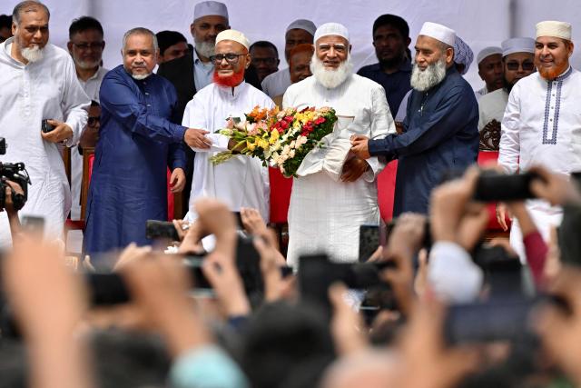 (FILES) Bangladesh's Jamaat-e-Islami party leader Ameer Shafiqur Rahman (centre R) presents a floral wreath to leader A.T.M. Azharul Islam (centre L) after his release from prison in Dhaka on May 28, 2025. After years of repression, Bangladesh's Islamist groups are mobilising ahead of February 12, 2026 elections, determined to gain a foothold in government as they sense their biggest opportunity in decades. At the centre of this formidable push is Jamaat-e-Islami, the country's largest and best-organised Islamist party. (Photo by Munir UZ ZAMAN / AFP)