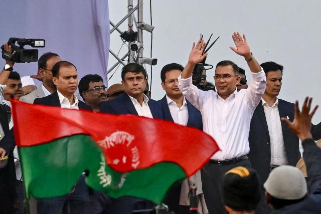 (FILES) Tarique Rahman (2R), son of former prime minister Khaleda Zia and Bangladesh Nationalist Party (BNP)'s acting chairman waves to supporters next to the party flag during a rally after his arrival in Dhaka on December 25, 2025. Bangladesh has been in political turmoil since a student-led revolt overthrew former prime minister Sheikh Hasina in August 2024, ending her 15-year autocratic rule. The Muslim-majority nation of 170 million people will hold its first elections since the uprising on February 12, 2026. (Photo by Munir UZ ZAMAN / AFP)