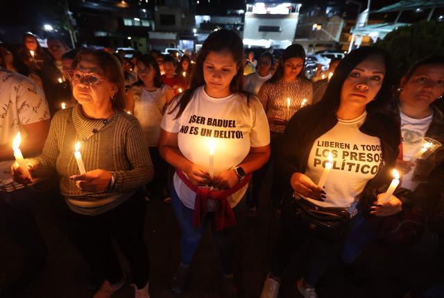 Relatives of political prisoners pray during a candle vigil outside El Rodeo I prison in Guatire, Miranda State, some 30 kilometers east of Caracas on January 11, 2026. Venezuelans waited on January 11 for more political prisoners to be freed as ousted president Nicolas Maduro defiantly claimed from his US jail cell that he was "doing well" after being seized by US forces a week ago. (Photo by Pedro MATTEY / AFP)