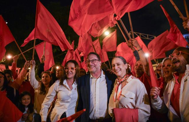 Costa Rica's Presidential candidate Eliezer Feinzaig Mintz of the Progressive Liberal Party and his wife RosalIa Waisman (R) pose for pictures with supporters as they arrive for the debate at the Supreme Electoral Tribunal (TSE) in San Jose, Costa Rica on January 11, 2026. Costa Rica will hold presidential election on February 1. (Photo by Ezequiel BECERRA / AFP)