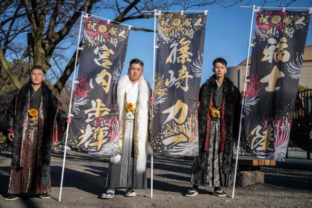 (L-R) Construction workers Ayuki Miyauchi, Riichi Shinozaki and Riku Fukushi pose for photographs before attending a ceremony at Todoroki Arena to mark "Coming of Age Day" to honour people who turn 20 this year to signify adulthood, in Kawasaki, Kanagawa prefecture on January 12, 2026. (Photo by Yuichi YAMAZAKI / AFP)