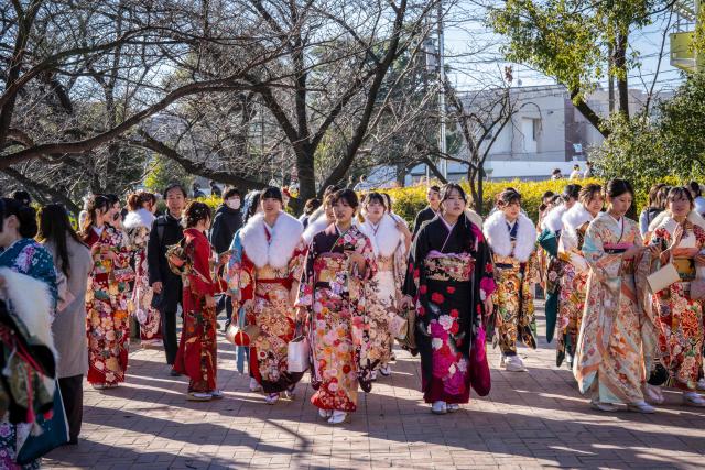 Women dressed in kimonos arrive to attend a ceremony at Todoroki Arena to mark "Coming of Age Day" to honour people who turn 20 this year to signify adulthood, in Kawasaki, Kanagawa prefecture on January 12, 2026. (Photo by Yuichi YAMAZAKI / AFP)