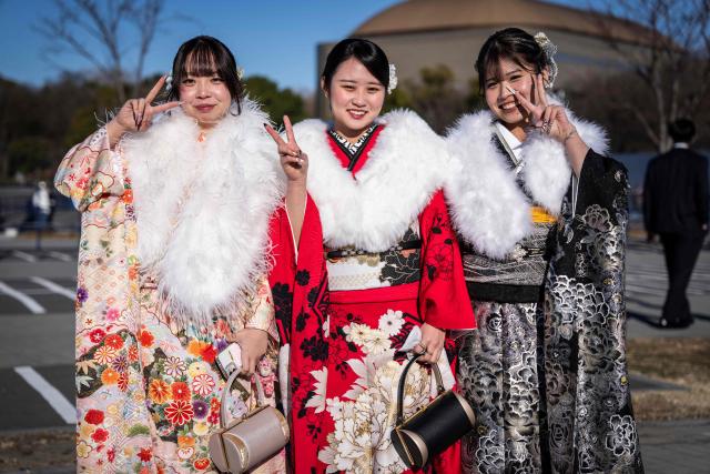 (L-R) College students Yui Yamamoto, Mamiko Saito and office worker Hina Endo pose for photographs before attending a ceremony at Todoroki Arena to mark "Coming of Age Day" to honour people who turn 20 this year to signify adulthood, in Kawasaki, Kanagawa prefecture on January 12, 2026. (Photo by Yuichi YAMAZAKI / AFP)