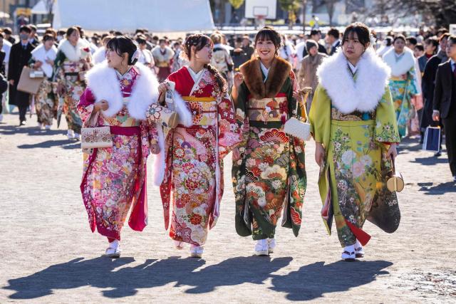 Women dressed in kimonos arrive to attend a ceremony at Todoroki Arena to mark "Coming of Age Day" to honour people who turn 20 this year to signify adulthood, in Kawasaki, Kanagawa prefecture on January 12, 2026. (Photo by Yuichi YAMAZAKI / AFP)