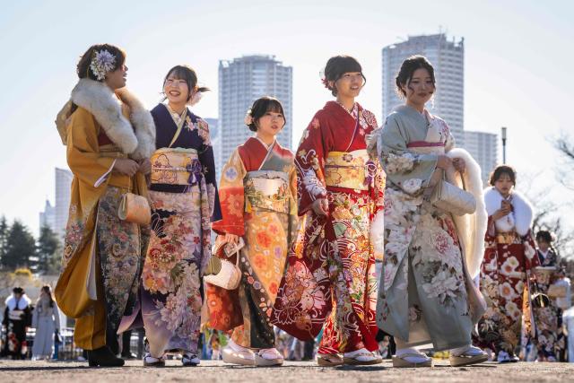 Women dressed in kimonos arrive to attend a ceremony at Todoroki Arena to mark "Coming of Age Day" to honour people who turn 20 this year to signify adulthood, in Kawasaki, Kanagawa prefecture on January 12, 2026. (Photo by Yuichi YAMAZAKI / AFP)