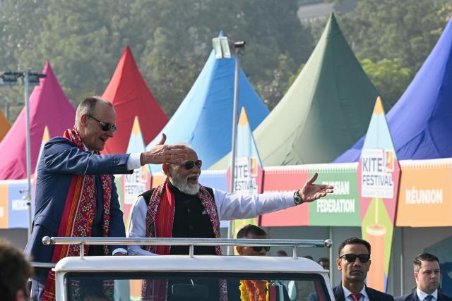 India's Prime Minister Narendra Modi (2L) and German Chancellor Friedrich Merz (L) share a laugh during the International Kite Festival in Ahmedabad on January 12, 2026. (Photo by Shammi MEHRA / AFP)