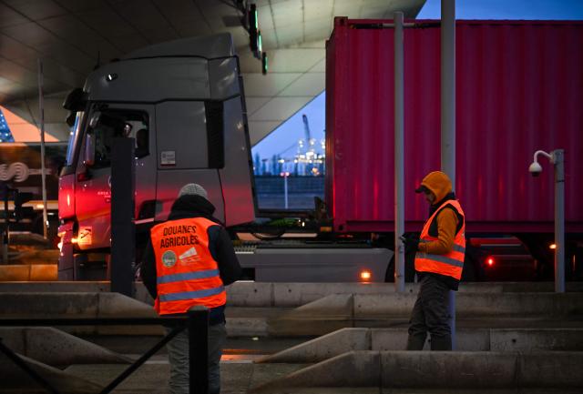 French farmer wearing fake safety vests of Customs stop truck drivers to inspect transport of foreign products, as part of national protests against the EU-Mercosur agreement and the government's handling of the contagious nodular dermatitis (CND) epidemic, on the harbour of Le Havre, northwestern France on January 12, 2026. (Photo by Lou BENOIST / AFP)