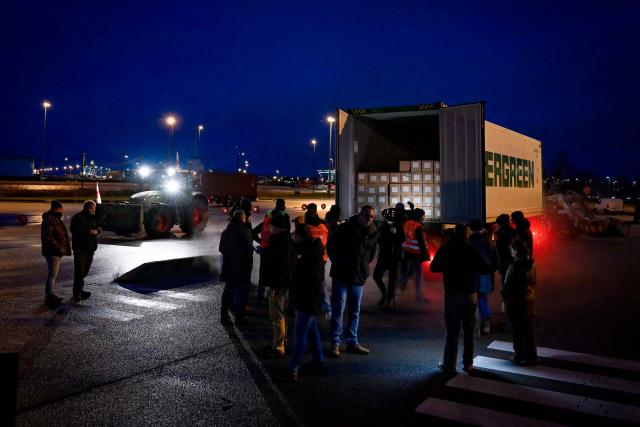 French farmers open a truck to inspect transport of foreign products, as part of national protests against the EU-Mercosur agreement and the government's handling of the contagious nodular dermatitis (CND) epidemic, on the harbour of Le Havre, northwestern France on January 12, 2026. (Photo by Lou BENOIST / AFP)