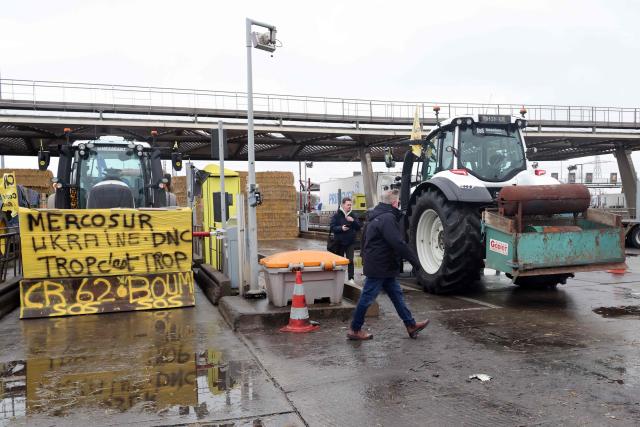 Tractors are parked as French farmers take part in a blockade at the exit of a toll booth on the A1 motorway near Fresnes-lès-Montauban, northern France, on January 12, 2026, as part of national protests against the EU-Mercosur agreement and the government's handling of the contagious nodular dermatitis (CND) epidemic. (Photo by Francois LO PRESTI / AFP)