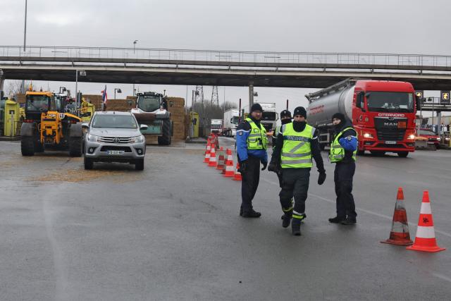 Gendarmes arrive as French farmers take part in a blockade at the exit of a toll booth on the A1 motorway near Fresnes-lès-Montauban, northern France, on January 12, 2026, as part of national protests against the EU-Mercosur agreement and the government's handling of the contagious nodular dermatitis (CND) epidemic. (Photo by Francois LO PRESTI / AFP)