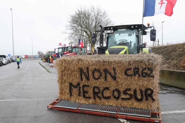 A haystack bearing the inscription "No to Mercosur" is seen on a tractor as French farmers take part in a blockade at the exit of a toll booth on the A1 motorway near Fresnes-lès-Montauban, northern France, on January 12, 2026, as part of national protests against the EU-Mercosur agreement and the government's handling of the contagious nodular dermatitis (CND) epidemic. (Photo by Francois LO PRESTI / AFP)