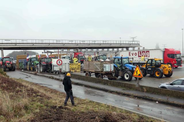Tractors are parked as French farmers take part in a blockade at the exit of a toll booth on the A1 motorway near Fresnes-lès-Montauban, northern France, on January 12, 2026, as part of national protests against the EU-Mercosur agreement and the government's handling of the contagious nodular dermatitis (CND) epidemic. (Photo by Francois LO PRESTI / AFP)