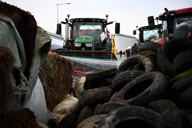 French farmers erect a makeshift barricade to block an oil depot as part of national protests against the EU-Mercosur agreement and the government's handling of the contagious nodular dermatitis (CND) epidemic, on the harbour of La Pallice in La Rochelle, southwestern France on January 12, 2026. (Photo by Christophe ARCHAMBAULT / AFP)