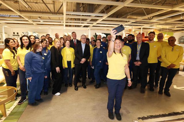 Britain's Prime Minister Keir Starmer poses for a photo with members of staff during a visit to a branch of Swedish furniture store Ikea in Croydon, south London on January 12, 2026. (Photo by Ian Vogler / POOL / AFP)