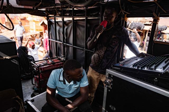 A supporter of opposition leader and presidential candidate for the National Unity Platform (NUP) Robert Kyagulanyi Ssentamu, popularly known as Bobi Wine, uses a sound system on a truck, to call his supporters to attend his final campaign rally in Kampala, on January 12, 2026. (Photo by Badru Katumba / AFP)