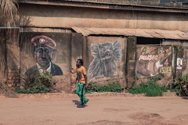 A pedestrian walks past a mural of opposition leader and presidential candidate for the National Unity Platform (NUP) Robert Kyagulanyi Ssentamu, popularly known as Bobi Wine, in Kampala, on January 12, 2026. (Photo by Badru Katumba / AFP)