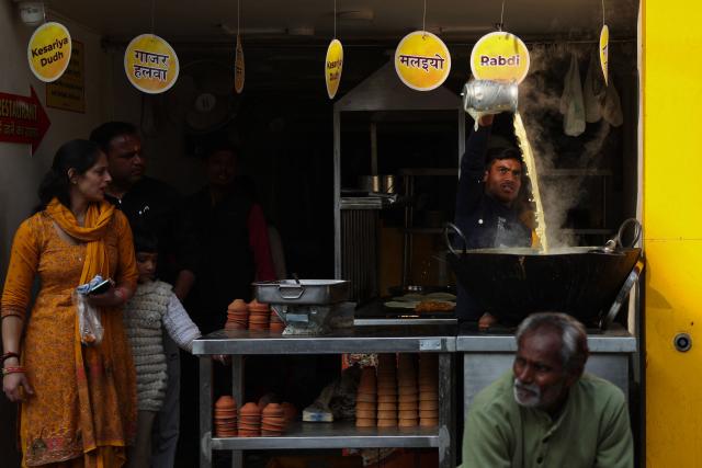 A vendor prepares saffron milk for the customers at a restaurant in Varanasi on January 12, 2026. (Photo by Niharika KULKARNI / AFP)