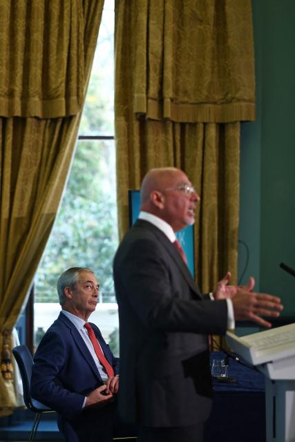 Sitting alongside Reform UK leader Nigel Farage (L), Former Conservative Party Chancellor of the Exchequer, Nadhim Zahawi (R) speaks after being unveiled as a new member of Reform UK at a press conference in London on January 12, 2026. (Photo by HENRY NICHOLLS / AFP)