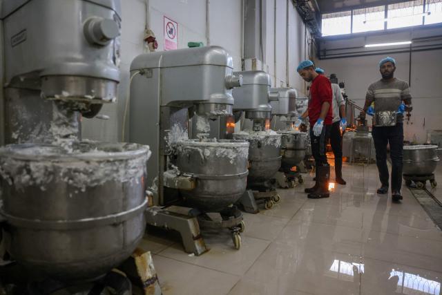 Palestinian employees prepare the filler of the sweet locally known as "al-Shatwi" (Winter) Crimbo sweets, as the Al-Arees factory gradually resumes operations after a hiatus caused by the Gaza war which led to shortages of raw materials used in their products, in Deir al-Balah, in the central Gaza Strip on January 12, 2026, following a US-brokered truce that halted the two-year war. (Photo by Bashar Taleb / AFP)