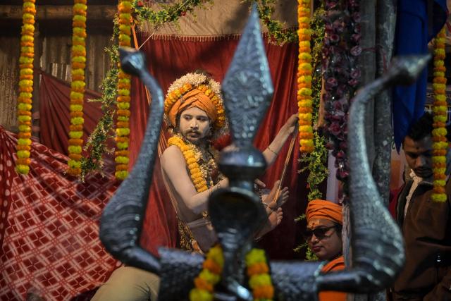 A sadhu or a Hindu holyman meets devotees at a transit camp ahead of the upcoming Hindu festival 'Gangasagar Mela', in Kolkata on January 12, 2026. (Photo by Dibyangshu SARKAR / AFP)