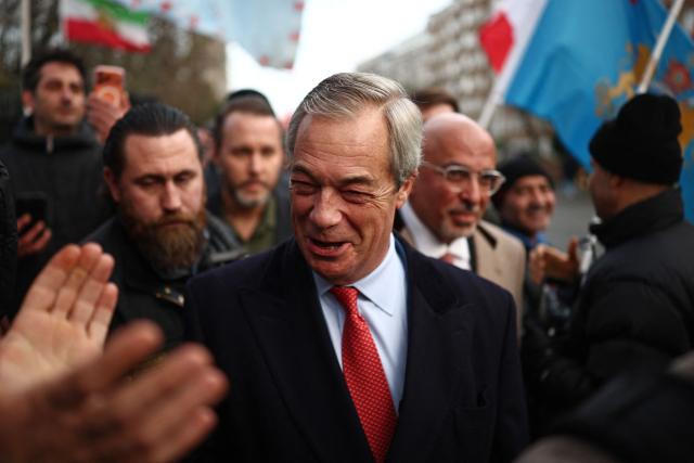 Former Conservative Party Chancellor of the Exchequer, Nadhim Zahawi (R), unveiled as a member of Reform UK earlier in the day, and Reform UK leader, Nigel Farage (C) visit anti-Iranian regime protesters during a gathering outside the Iranian Embassy, central London, on January 12, 2026. (Photo by HENRY NICHOLLS / AFP)