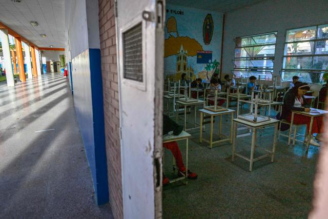 Students sit inside a classroom at the start of the new school year in Caracas on January 12, 2026. The United States' bombing of Venezuela dominated the agenda as schools returned to term, following instructions from the government, which asked for an assessment of how the operation had impacted students. The incursion on January 3 also led to the arrest of ousted president Nicolas Maduro and his wife, Cilia Flores, who are facing trial for drug trafficking in New York. (Photo by Juan BARRETO / AFP)