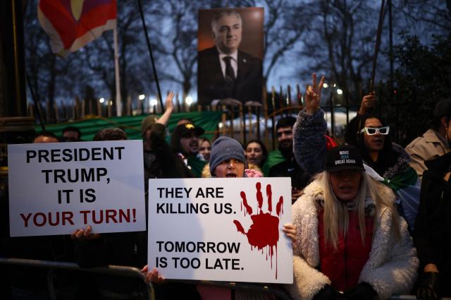 Anti-Iranian regime protesters wave Iranian flags during a gathering outside the Iranian Embassy, central London, on January 12, 2026. (Photo by Henry NICHOLLS / AFP)