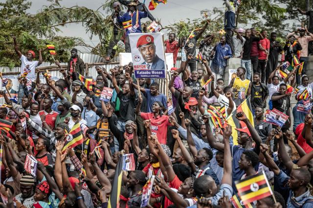 Supporters of opposition leader and presidential candidate for the National Unity Platform (NUP) Robert Kyagulanyi Ssentamu, popularly known as Bobi Wine, chant slogans and hold flags as they celebrate his arrival at the party’s final campaign rally ahead of the 2026 general elections in Kampala on January 12, 2026. (Photo by Luis TATO / AFP)