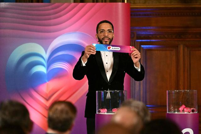 Moderator Austrian singer Cesar Sampson holds a draw for Albania during the draw session for the two semi-final events of the Eurovision Song Contest 2026 on stage at the Vienna’s city hall in Vienna, Austria, on January 12, 2026. Vienna hosts the Eurovision Song Contest 2026 on May 12-14. (Photo by Joe Klamar / AFP)