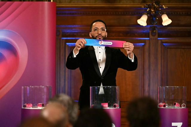 Moderator Austrian singer Cesar Sampson holds a draw for Denmark during the draw session for the two semi-final events of the Eurovision Song Contest 2026 on stage at the Vienna’s city hall in Vienna, Austria, on January 12, 2026. Vienna hosts the Eurovision Song Contest 2026 on May 12-14. (Photo by Joe Klamar / AFP)