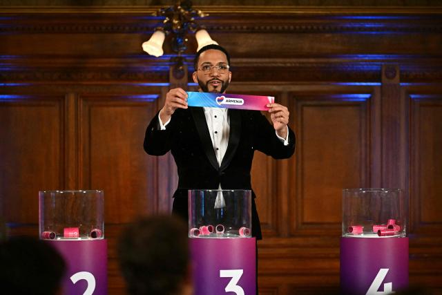 Moderator Austrian singer Cesar Sampson holds a draw for Armenia during the draw session for the two semi-final events of the Eurovision Song Contest 2026 on stage at the Vienna’s city hall in Vienna, Austria, on January 12, 2026. Vienna hosts the Eurovision Song Contest 2026 on May 12-14. (Photo by Joe Klamar / AFP)