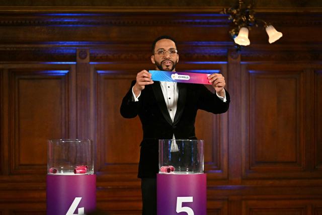 Moderator Austrian singer Cesar Sampson holds a draw for Cyprus during the draw session for the two semi-final events of the Eurovision Song Contest 2026 on stage at the Vienna’s city hall in Vienna, Austria, on January 12, 2026. Vienna hosts the Eurovision Song Contest 2026 on May 12-14. (Photo by Joe Klamar / AFP)