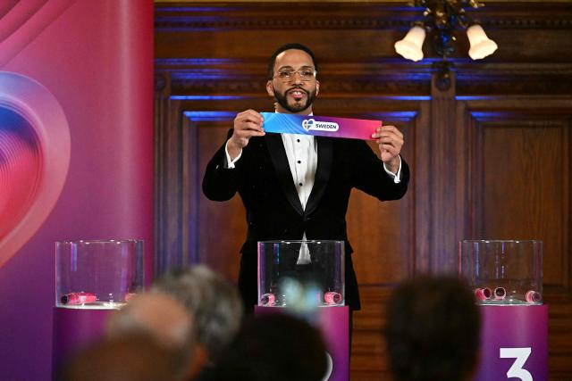 Moderator Austrian singer Cesar Sampson holds a draw for Sweden during the draw session for the two semi-final events of the Eurovision Song Contest 2026 on stage at the Vienna’s city hall in Vienna, Austria, on January 12, 2026. Vienna hosts the Eurovision Song Contest 2026 on May 12-14. (Photo by Joe Klamar / AFP)