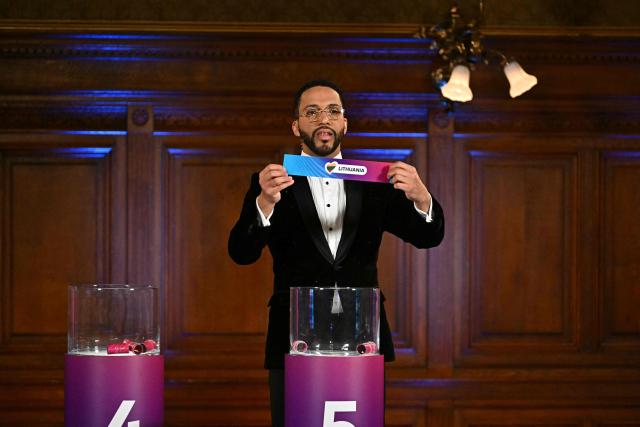 Moderator Austrian singer Cesar Sampson holds a draw for Lithuania during the draw session for the two semi-final events of the Eurovision Song Contest 2026 on stage at the Vienna’s city hall in Vienna, Austria, on January 12, 2026. Vienna hosts the Eurovision Song Contest 2026 on May 12-14. (Photo by Joe Klamar / AFP)